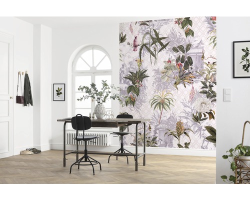 Une pièce lumineuse avec une table, des chaises et un mur avec du papier peint botanique.