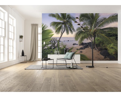 Heller Raum mit Fototapete eines Palmenstrandes, eingerichtet mit Stuhl, Tisch, Stehlampe und Teppich