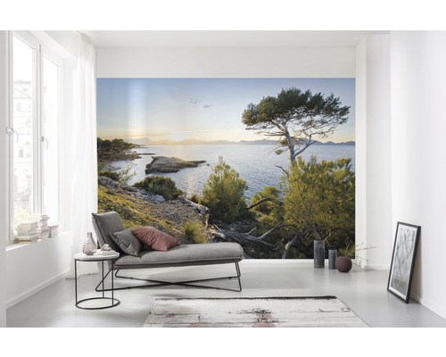 Wohnraum mit Fototapete einer Küstenlandschaft mit Meerblick.
