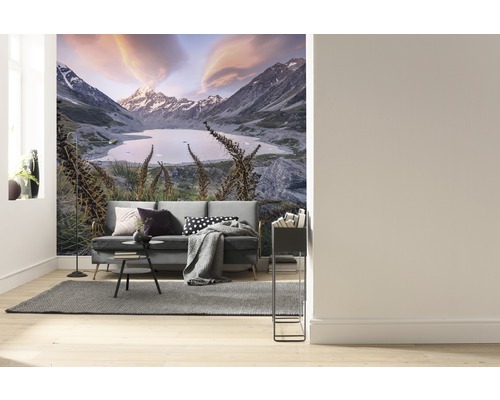 Salon avec papier peint photo d''un paysage de montagne avec lac et canapé.