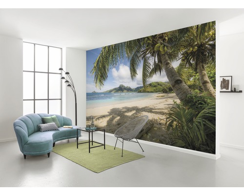 Wohnraum mit Fototapete mit Strandmotiv, Sofa, Sessel und Teppich