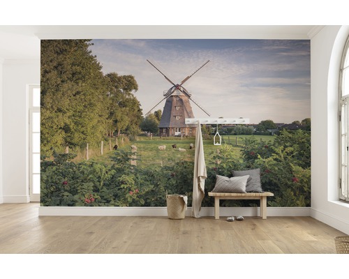 Wandbild mit einer Windmühle, Schafen und üppigem Grün in einem hellen Raum.