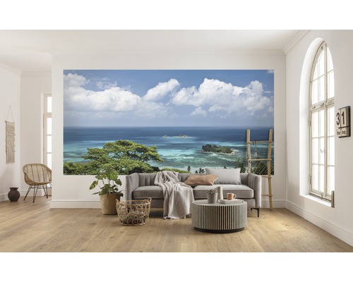 Wohnraum mit Fototapete eines Küstenpanoramas mit Meerblick und bewölktem Himmel