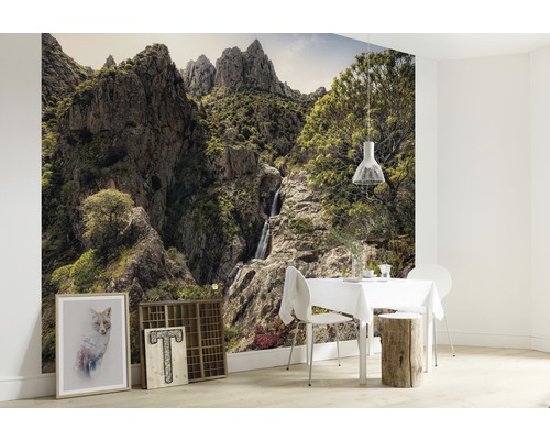 Papier peint représentant un paysage de montagne et une cascade dans une salle à manger lumineuse.