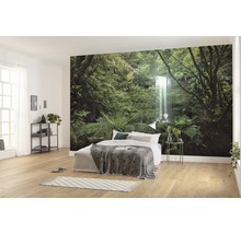 Chambre lumineuse avec papier peint photo d''une forêt avec cascade, lit avec couverture et table de chevet