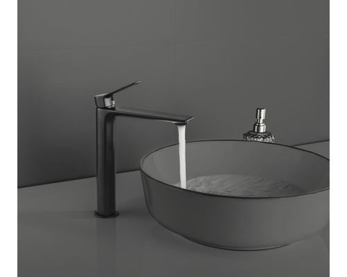 Waschtischarmatur neben Waschbecken mit Wasser