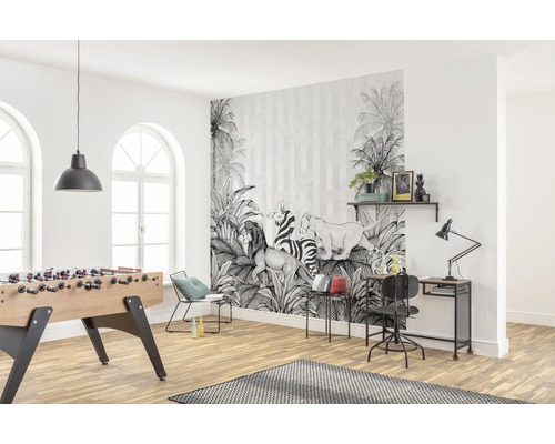 Helles Wohnzimmer mit einer Fototapete mit Dschungelmotiven, Tischfußball und Schreibtisch