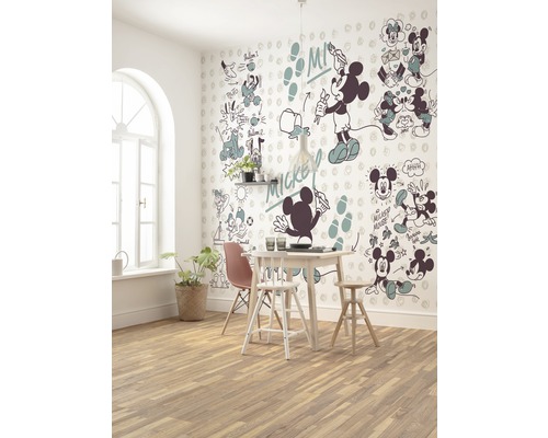 Ein Esszimmer mit Esstisch, Stühlen und einer Wand mit Mickey-Mouse-Motiven.