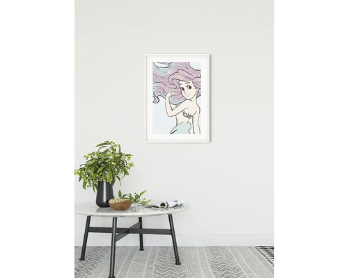 Image encadrée d''une sirène sur le mur au-dessus d''une table avec décoration.