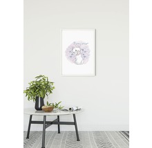 Tableau mural décoratif avec motif de chat dans un cadre blanc au-dessus d''une table avec décoration