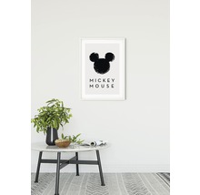 Impression d''art décorative avec motif Mickey Mouse encadrée au mur au-dessus d''une table avec décoration.