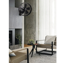 Salon avec ventilateur mural, fauteuil et table basse