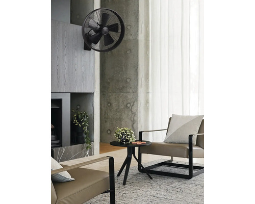 Salon avec ventilateur mural, fauteuil et table basse