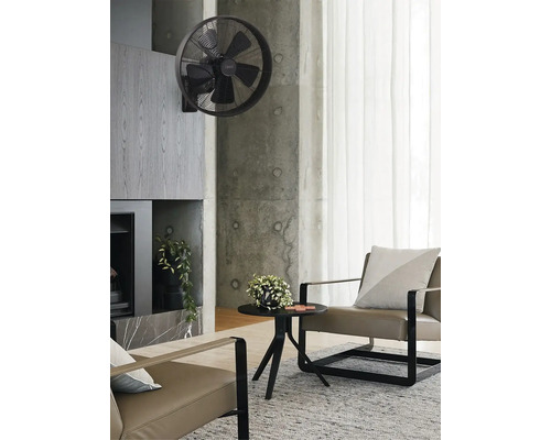 Salon avec ventilateur mural, fauteuils et table d''appoint