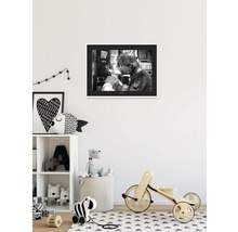 Chambre d''enfant avec une photo en noir et blanc au mur, une étagère avec des jouets et un vélo en bois