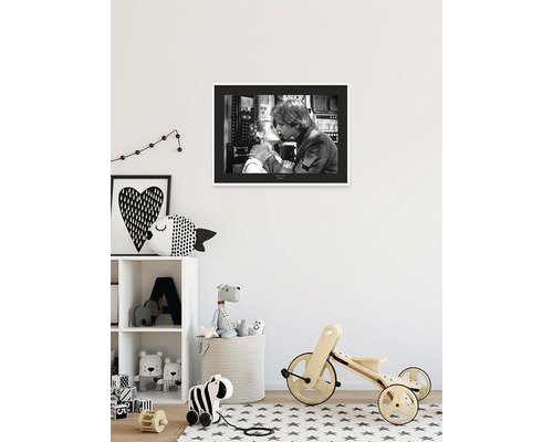 Chambre d''enfant avec une photo en noir et blanc au mur, une étagère avec des jouets et un vélo en bois