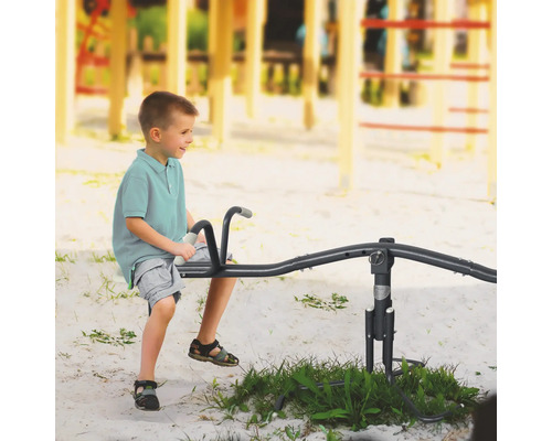 Garçon sur une balançoire à bascule dans une aire de jeux