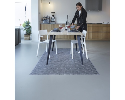 Esstisch mit Teppich in einem hellen Esszimmer mit Stühlen und Dekoration