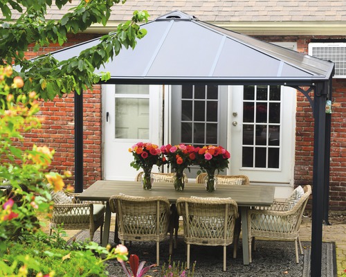 Gartenszene mit Pavillon, Esstisch und Stühlen im Freien.