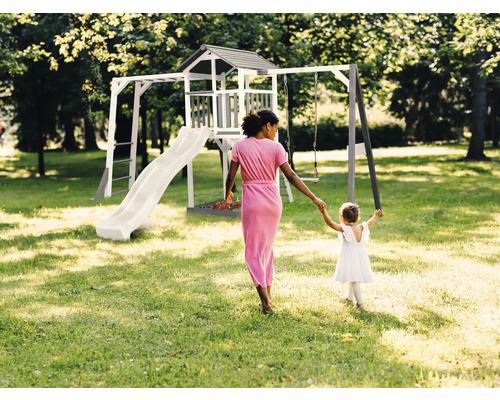 Spielplatz mit Rutsche, Schaukel und Spielhaus im Garten mit Frau und Kind