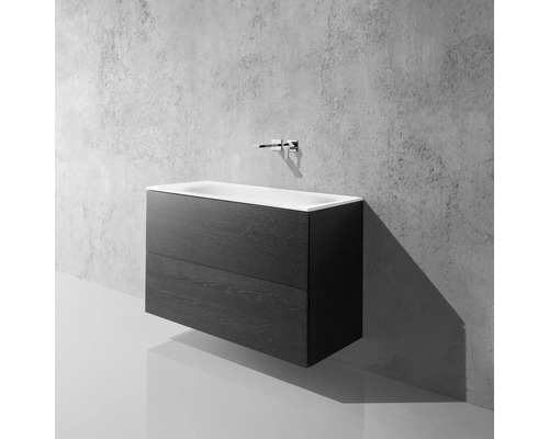 Meuble sous-lavabo avec deux tiroirs et lavabo à poser devant un mur en béton