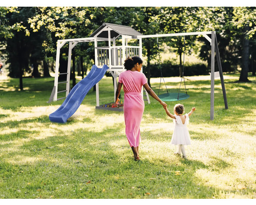 Spielturm mit Rutsche und Schaukel im Garten mit Mutter und Kind