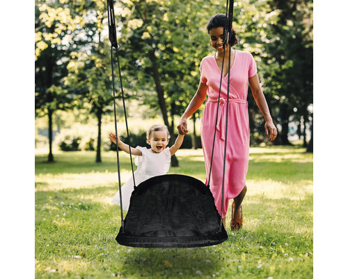 Mutter und Kind mit Nestschaukel im Garten