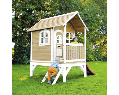 Maisonnette en bois avec toboggan dans le jardin avec des enfants