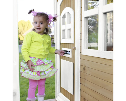 Une petite fille met une lettre dans la boîte aux lettres d''une cabane en bois.