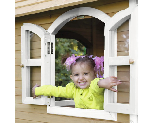 Un enfant souriant regarde par la fenêtre d''une cabane en bois.