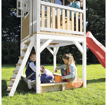 Maisonnette avec toboggan et bac à sable avec des enfants jouant dans le jardin
