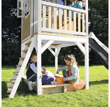 Maisonnette avec toboggan, échelle et bac à sable pour enfants dans le jardin.