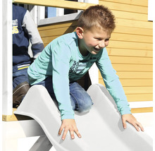 Garçon glissant sur un toboggan d''une cabane de jeux
