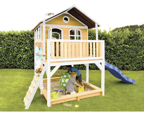 Cabane de jeu avec bac à sable et toboggan dans le jardin avec des enfants qui jouent.