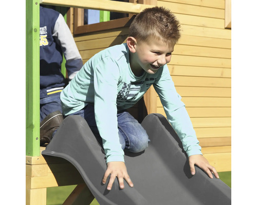 Junge rutscht auf einer Rutsche eines Spielturms