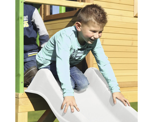 Junge rutscht auf einer Spielplatzrutsche