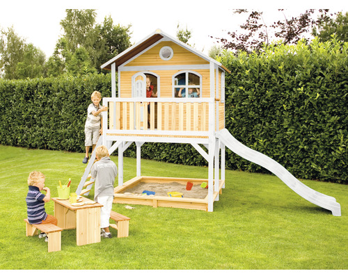 Maisonnette avec toboggan, bac à sable et table de pique-nique dans le jardin.