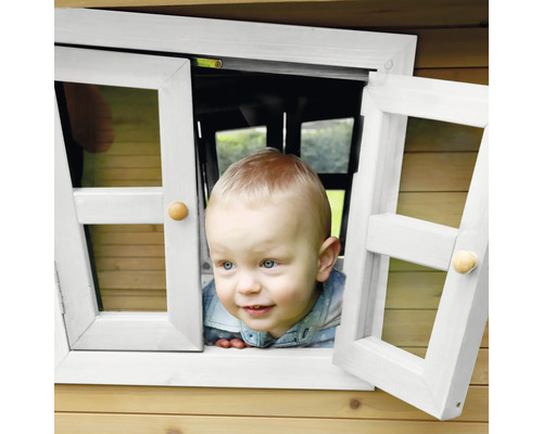 Un jeune enfant regarde par la fenêtre d''une cabane de jeu