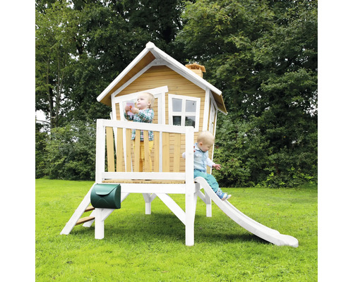 Cabane de jeu en bois avec toboggan et boîte aux lettres dans le jardin avec deux enfants