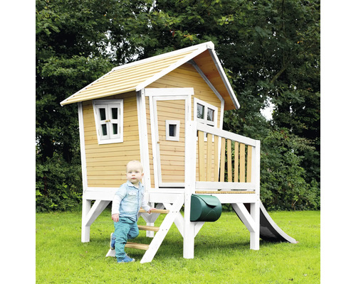 Cabane de jeux en bois avec toboggan et boîte aux lettres dans le jardin avec enfant