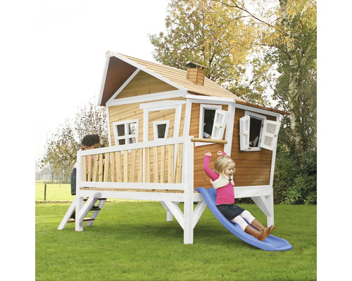 Maison de jeux pour enfants avec toboggan et enfants dans le jardin.