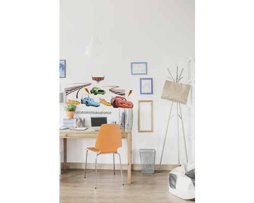 Chambre d''enfant décorée avec des stickers muraux sur le thème de la voiture au-dessus d''un bureau