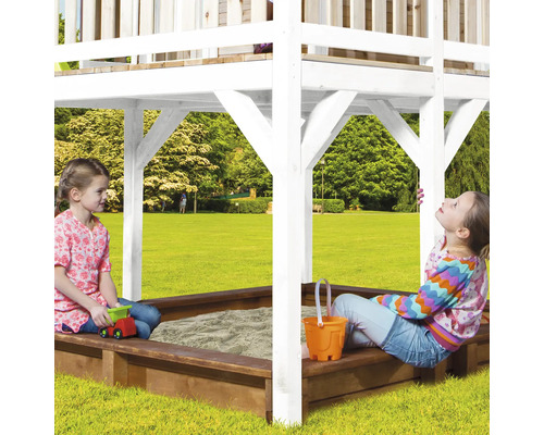 Zwei Kinder spielen in einem Sandkasten mit Spielhaus im Garten.