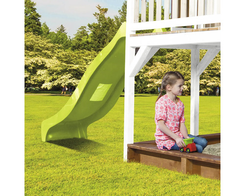 Spielplatz mit Rutsche und Sandkasten mit spielendem Kind