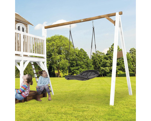 Aire de jeux avec balançoire et deux enfants dans le jardin.