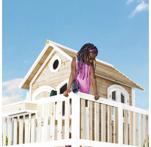 Fille sur une cabane avec une clôture en bois et une tour de guet sous un ciel bleu