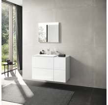 Salle de bains avec meuble sous-vasque blanc, miroir et carrelage grand format.