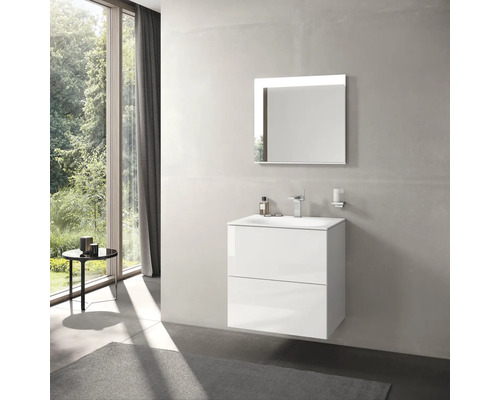 Salle de bains moderne avec meuble sous-lavabo blanc, miroir avec éclairage et fenêtre donnant sur la verdure.