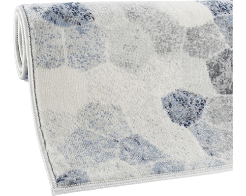 Tapis avec motif géométrique, partiellement enroulé