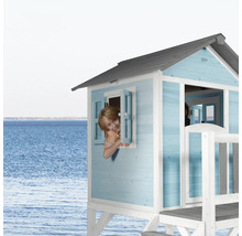 Un enfant regarde par la fenêtre d''une cabane de jeu bleue et blanche sur la plage